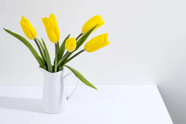 Bukiet Żółtych Tulipanów Jest Stole Naprzeciwko Białej Ściany Przestrzeń Kopiowania — Zdjęcie stockowe