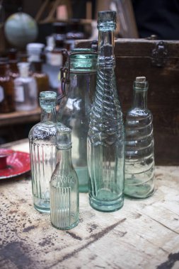 Londra, İngiltere - 13 Şubat 2020 Spitalfields bit pazarı. Ahşap bir masada farklı şekillerde cam şişeler.
