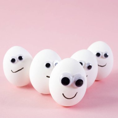 konsept sosyal ağlar iletişim ve duygular - pembe arka planda yumurtalar göz kırpıyor. Boşluğu kopyala