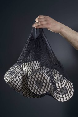 Adamın eli tuvalet kağıdı rulolarının olduğu bir torba tutuyor. Hijyen konsepti..