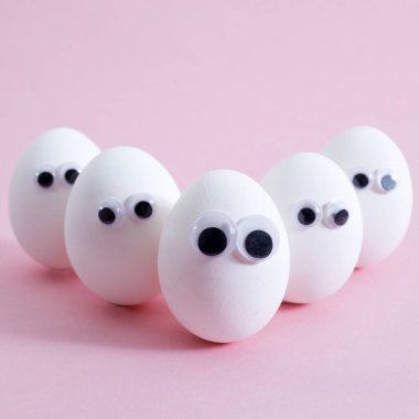 konsept sosyal ağlar iletişim ve duygular - pembe arka planda yumurtalar göz kırpıyor. Boşluğu kopyala