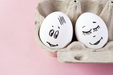 konsept sosyal ağlar iletişim ve duygular - pembe arka planda yumurtalar göz kırpıyor. Boşluğu kopyala