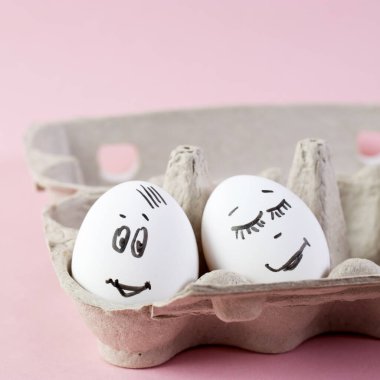 konsept sosyal ağlar iletişim ve duygular - pembe arka planda yumurtalar göz kırpıyor. Boşluğu kopyala