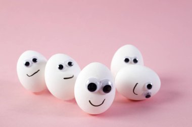 konsept sosyal ağlar iletişim ve duygular - pembe arka planda yumurtalar göz kırpıyor. Boşluğu kopyala