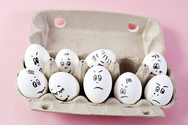 concept social networks communication and emotions - eggs wink on pink background. Copy space