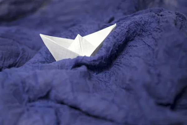Papierkariertes Boot Auf Blau Drapiertem Stoff Symbolisiert Die Wellen Und — Stockfoto