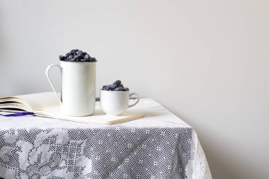 Masada iki alüminyum ve hanımeli porselen bardak var. Durgun hayat. Boşluğu kopyala.
