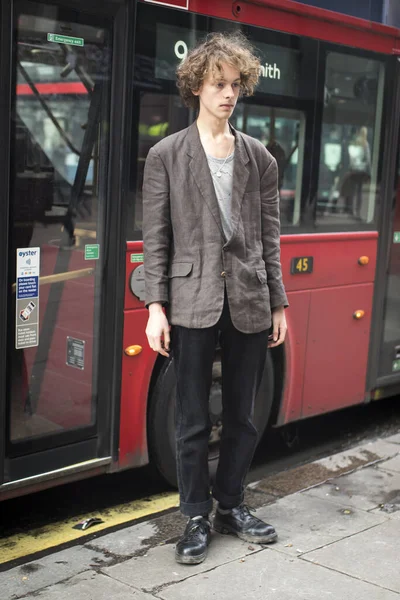 2020年1月15日街上时尚人士 街上风格 身着米黄色夹克和黑色裤子 卷曲头发的年轻人站在公共汽车的前排 — 图库照片
