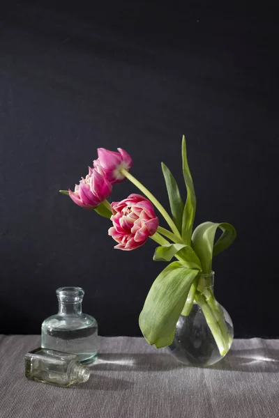 Trois Tulipes Éponge Rouge Dans Vase Rond Avec Petites Bouteilles — Photo