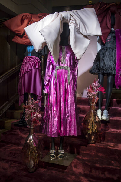 London, UK - 15 February, 2020, Black mannequins in a pink violet floral dress and a large beige bow and vase with dried flower in a window in a Liberty store on Regent Street