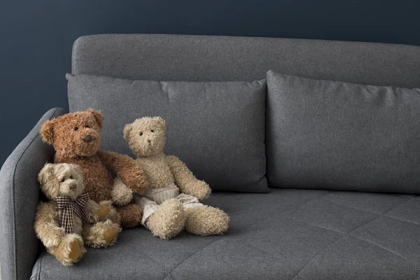 Three teddy bears on grey sofa. The concept of self-isolation. Stay home. Copy space