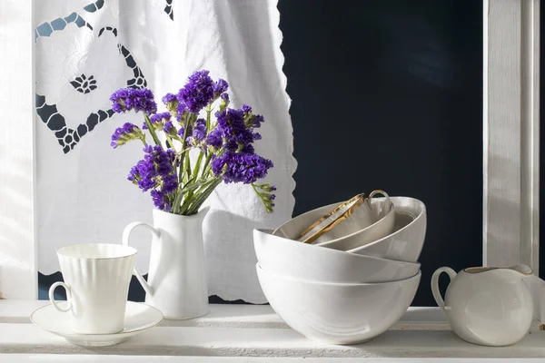 一束石榴和一套白菜 瓷浆壶 咖啡杯 放在深蓝色背景的白色架子上的碗 — 图库照片