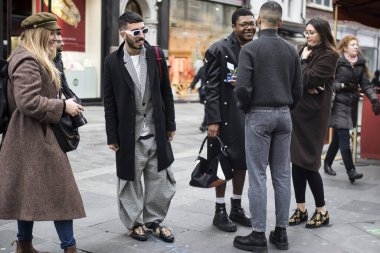 Londra, İngiltere - 15 Ocak 2020, sokaktaki popüler insanlar. Sokak tarzı. Kısa saçlı, sakallı, bej renkli damalı bir adam kalabalığın arasında yürüyor..