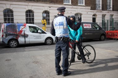 Londra, İngiltere - 15 Ocak 2020, Bir polis memuru bisikletli bir kuryeyi durdurdu ve belgeleri kontrol etti