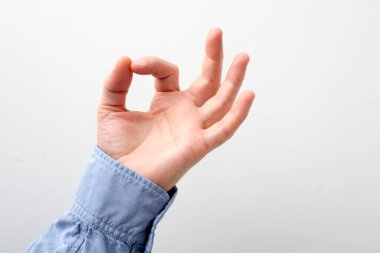 Mavi gömlekli bir adam beyaz arka plandaki bir şeye dokunuyor ya da işaret ediyor. Kapatın. Boşluğu kopyala