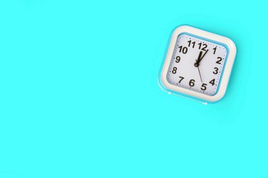 Mavi arka planda mavi çalar saat. Yukarıdan vurulmuş. Mesaj için yer var. Boşluğu kopyala