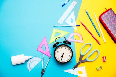 Okula başlamak, okula dönmek, eğitim, mavi ve sarı arka planda okul malzemeleriyle düz yatak sahnesi. Boşluğu kopyala