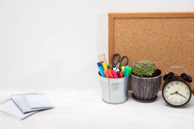 Uzayı kopyala İşyeri ofis çalışanı. Çalar saat, seramik kap, yazı tahtası, makaslı kova, keçeli kalem, cetvel, öğrenci masasında üç defter..