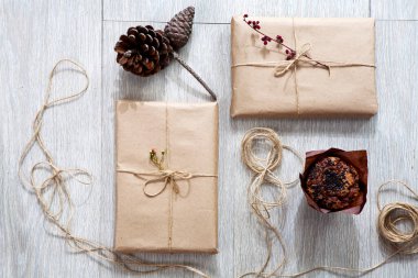 Hediye paketi için çeşitli eşyalar masanın üzerinde. Hediyeler paketlendi bile. Koni, paketlenmiş kitaplar.