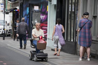 LONDON, İngiltere - 17 Eylül 2019: Bir adam Bricklane 'deki yaşlılar için motosiklete biniyor