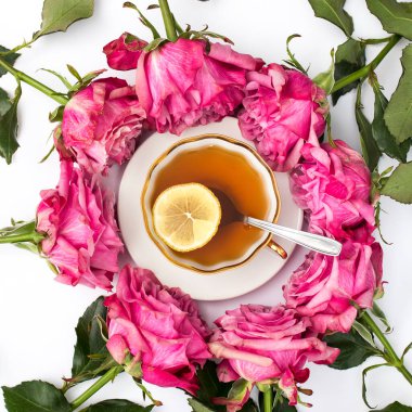 Bir fincan kırmızı gül, bir fincan çayı limon ve çay tabağıyla çevreler. Çember, Boşluğu Kopyala