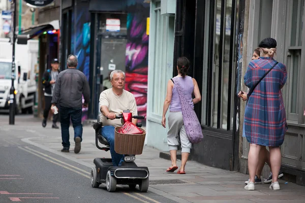 LONDON, İngiltere - 17 Eylül 2019: Bir adam Bricklane 'deki yaşlılar için motosiklete biniyor