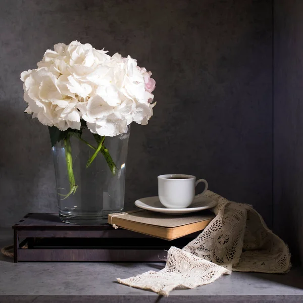 Λευκή Ορτανσία Γυάλινο Βάζο Ένα Μικρό Φλυτζάνι Καφέ Ένα Βιβλίο — Φωτογραφία Αρχείου