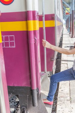 Bir kadın trene elinde demiryolu ile girer.