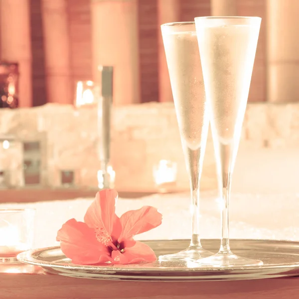 Due bicchieri di champagne con candela e fiore rosso vicino alla jacuzzi — Foto Stock