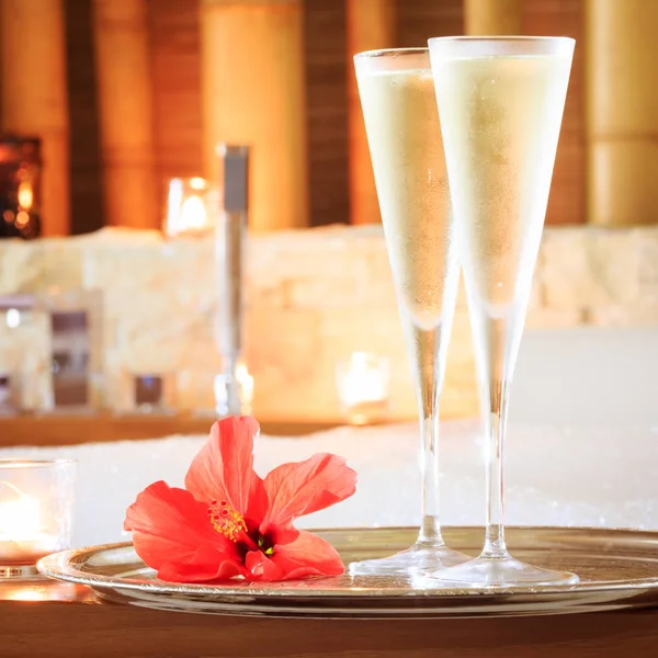 Deux verres de champagne avec bougie et fleur rouge près du jacuzzi — Photo