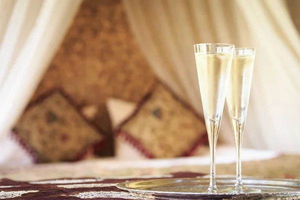 Twee champagneglazen met oosterse hemelbed op de achtergrond — Stockfoto