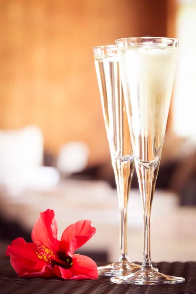 Två glas champagne med röd blomma i en spa-lounge. Spa ti — Stockfoto