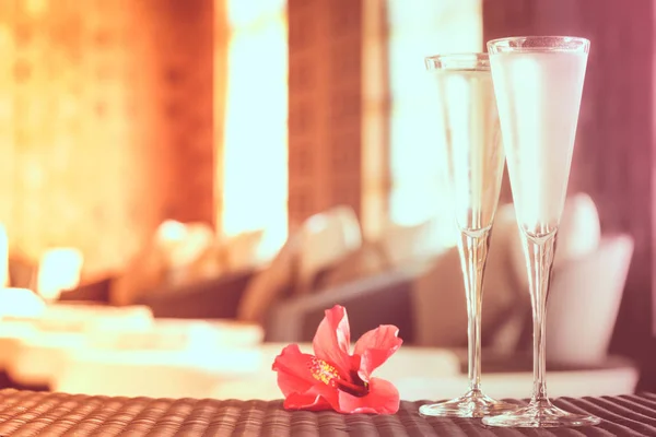 Twee glazen van champagne met rode bloem in een spa salon. Spa ti — Stockfoto