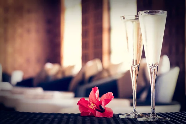 Zwei Gläser Champagner mit roten Blüten in einer Wellness-Lounge. Wellnessbereich — Stockfoto