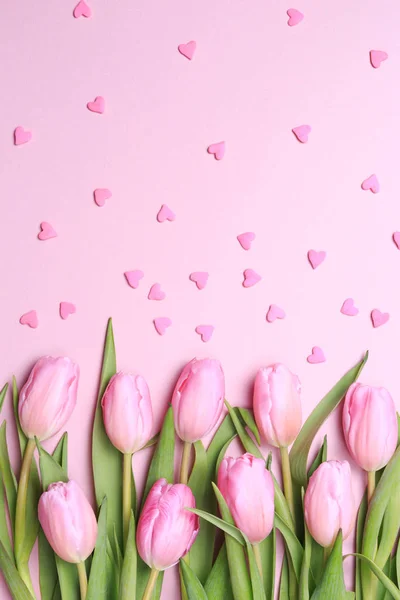 Pink tulips with pink heart sprinkles on the pink background. Fl — Stock Photo, Image