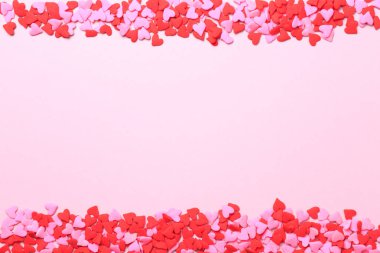 Pembe ve kırmızı kalp, pembe arka plan sprinkles. Düz yatıyordu, t
