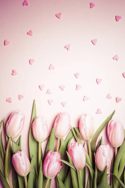 Pink tulips with pink heart sprinkles on the pink background. Fl — Stock Photo, Image