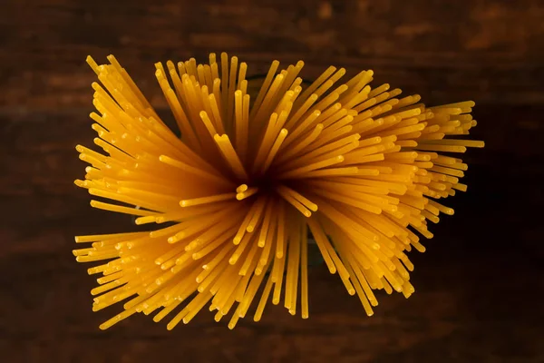 Glutenfreie Pasta auf dunklem Hintergrund. Draufsicht auf rohe Spaghetti. — Stockfoto