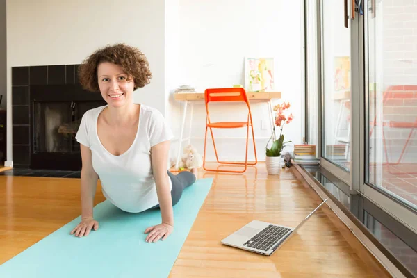 Kadın onun oturma odasında bilgisayarda online app Yoga yapıyordum