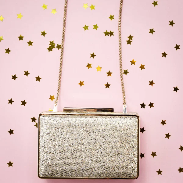 Festive evening golden clutch with star sprinkles on pink. Holid