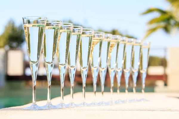 Muitos copos de champanhe ou prosecco perto da piscina resort em um luxu — Fotografia de Stock