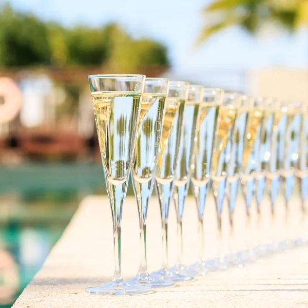 Muitos copos de champanhe ou prosecco perto da piscina resort em um luxu — Fotografia de Stock