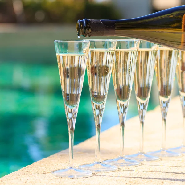 Muitos copos de champanhe ou prosecco perto da piscina resort em um luxu — Fotografia de Stock