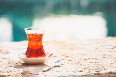 Suya yakın açık havada sıcak Türk çayı. Türk çayı ve geleneksel
