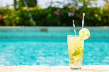 Bir resort havuz kenarında Mojito kokteyl. Lüks tatil kavramı. Açık havuzu arka plan. Yatay
