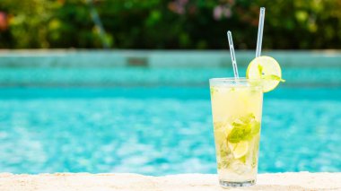 Bir resort havuz kenarında Mojito kokteyl. Lüks tatil kavramı. Açık havuzu arka plan. Yatay, geniş ekran formatı