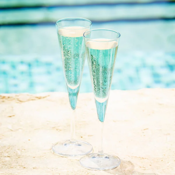 Dois copos de prosecco na beira de uma piscina do resort. Conceito — Fotografia de Stock