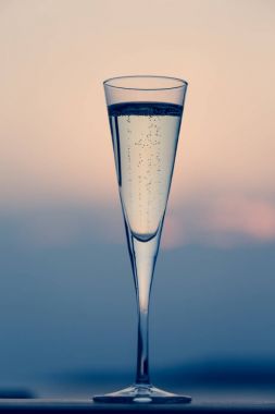 Bir bardak prosecco, gün batımında ahşap bir iskele. Lüks resort vaca