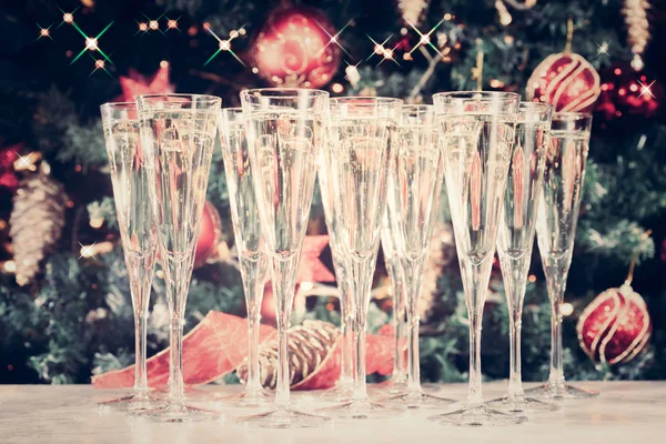 Glasses of champagne with Christmas tree background and sparkles