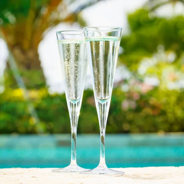 Two glasses of prosecco   at the edge of a resort pool. Concept — Stock Photo, Image